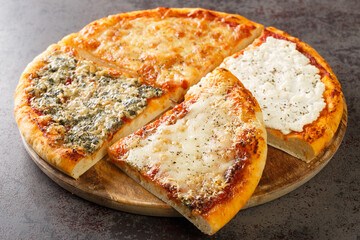 Delicious Italian four cheese pizza with tomato sauce, gorgonzola, ricotta, parmesan and mozzarella close-up on a wooden board on the table. Horizontal