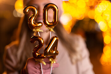 Young woman holding 2024 number for new year eve