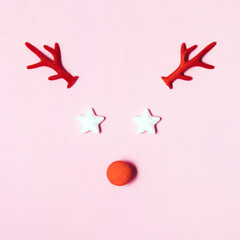 Christmas decorative elements, creative layout against pastel pink background. Christmas tales inspiration. Reindeer with red nose idea. 