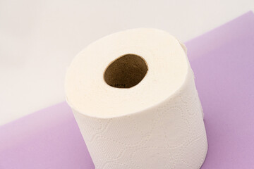 Roll of toilet paper on purple table.