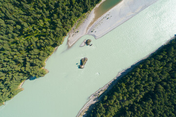 Drone aerial top view of mountain river and forest, Lonely island in a flowing swift turquoise...