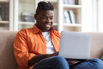 Cheerful african american man digital nomad working from home