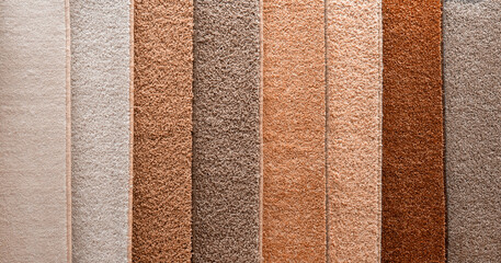 Variety of carpets and carpets of different colors on the stand in the store or the factory....