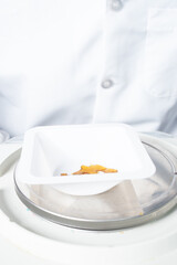 Gloved Worker Weighing & Packaging Cannabis Extract