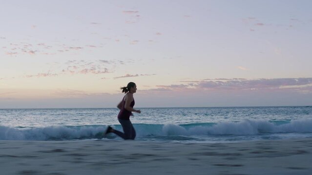 Woman, fitness or running on sunset beach workout, training or exercise in healthcare wellness, marathon or body cardiology. Runner, sports athlete or sprinter by ocean, nature sea or sunrise water
