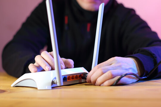 connecting internet cable to router with antennas on table