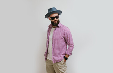 Fashion portrait of a young bearded hipster man. Handsome man in a hat isolated on white background.
