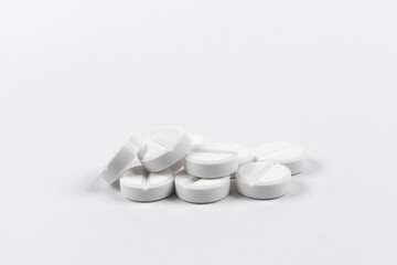 many white round medical tablets for humans and animals, medicinal antibiotics pills medicine closeup