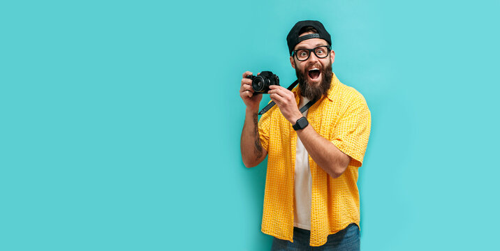 Young hipster photographer isolated on blue background. Lifestyle work as a freelance