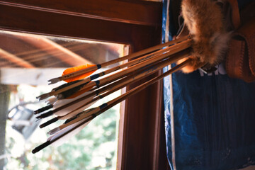 Traditional archery  arrows stuffed into a quiver and hung on the wall.