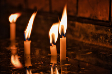 Candles burning in front of the dim tiled wall in the  church. For christmas wishes and pray...