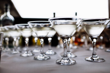 Many glasses with martini cocktails on table. Luxury cocktail drink in restaurant bar. Classy beverage celebration party for new year, christmas, valentine, birthday.