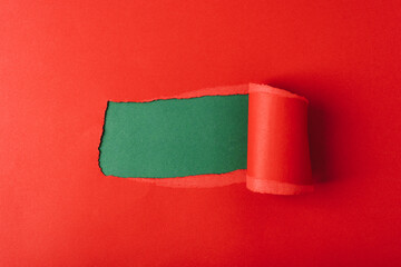 Hole in red paper on green background. Mockup