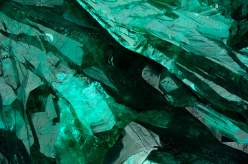 Dioptase crystal macro detail texture background. close-up raw rough unpolished semi-precious...