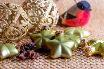 Close-up of gold Christmas baubles and green stars.