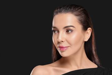 Obraz premium Portrait of young woman with beautiful makeup on black background. Space for text