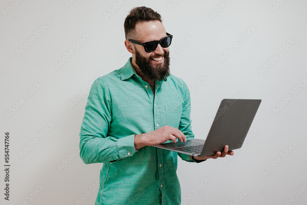 Wall mural portrait of smiling positive businessman standing with portable computer in hands. laptop concept. p
