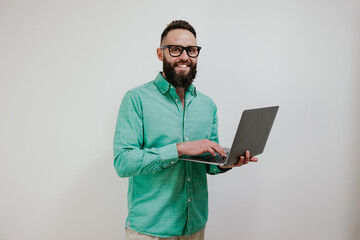 Portrait of smiling positive businessman standing with portable computer in hands. Laptop concept....