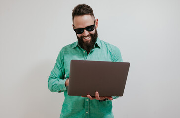 Portrait of smiling positive businessman standing with portable computer in hands. Laptop concept. Promotion poster. Programmer, web developer holding a laptop in his hands and looking at the camera