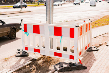 Protective barrier fence installed around new just installed pole on the sidewalk. Pedestrian...