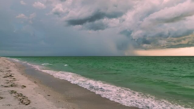 Dark stormy clouds forming on gloomy sky during heavy rainfall season over sea baech surface in evening