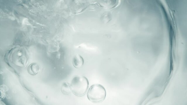 Pure Water Poured Into Glass closeup on light gray background. Super slow motion. Quenching thirst concept. Clear fresh drinking water filling glass close up