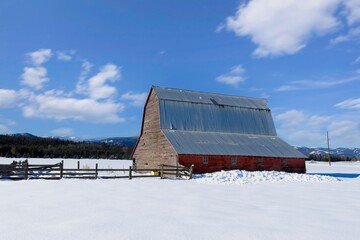 Red barn in a snow covered field. © Gregory Johnston