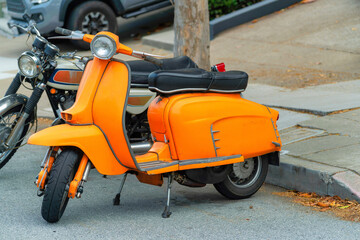 Row of colorful motor bikes or motor cylces parked near a curb in a suburban area of the city or neighborhood