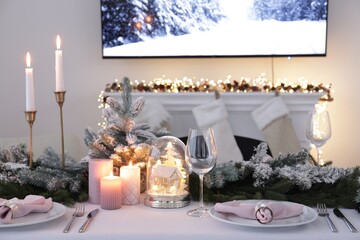 Beautiful festive place setting with Christmas decor on table indoors