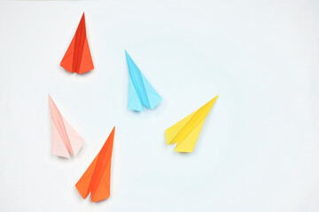Handmade colorful paper planes on white table, flat lay. Space for text