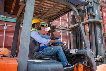 Fototapeta na wymiar Foreman working at container stock yard with drive a loader forklift steering wheel control for transport handling.