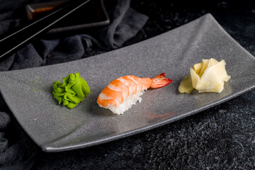 sushi with shrimp on plate on dark table