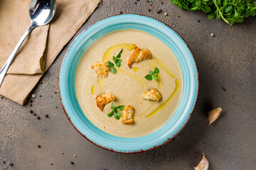 Cream soup of mushrooms on blue bowl top view