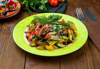 asian salad with beef, vegetables and spicy pepper on wooden table