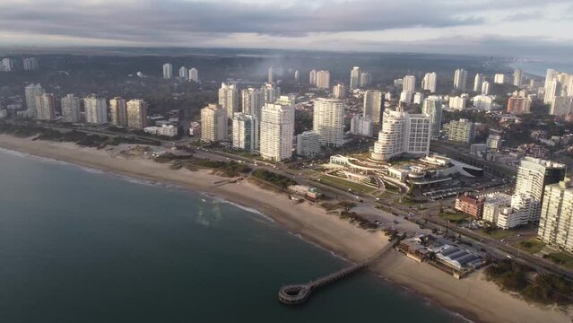 Punta del Este Beach at sunset. Dock and city at background. Aerial footage