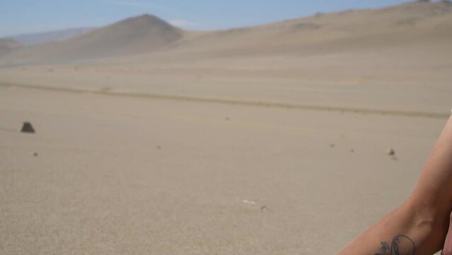 Person's Hand Holding Up Sand And Dropping It In Strong Wind In Desert, Lima, Peru