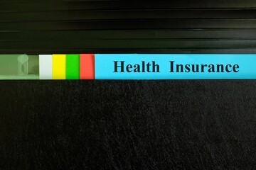 Health insurance file record in black binder folder. Health insurance benefit concept.