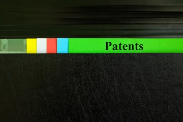 Patents file record in black binder folder. Patent and patenting business legal concept.	