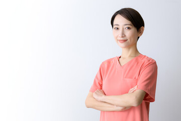 Image of a scruffy, smiling, scruffy, user-friendly doctor (female doctor) with her arms crossed