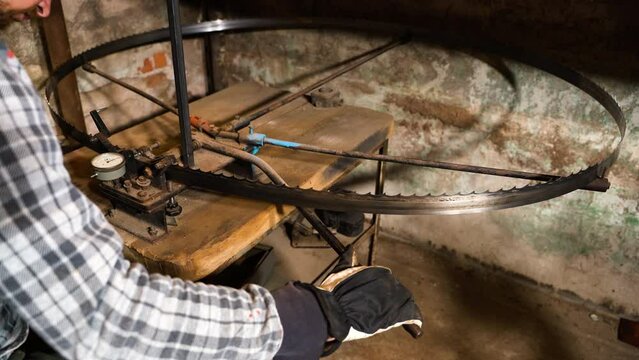 Worker adjusting band saw by bending path on bending table