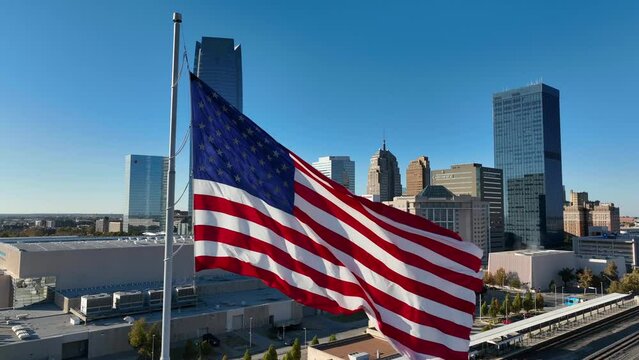 American flag in Oklahoma City OK. Aerial view of city on windy day.