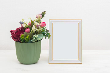 Blank picture frame mockup on white cupboard. White living room design. Home staging and minimalism concept
