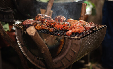 Barbequing chicken drumsticks on a BBQ grill,