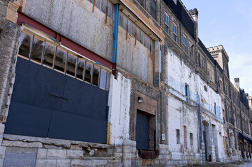 facade of abandoned rundown warehouse dock with boarded windows and broken glass in milwaukee 