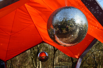 disco ball with small square mirrors, outdoor party with mirror disco ball, mirror ball on bright...