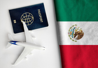 Flag of Mexico with passport and toy airplane. Flight travel concept
