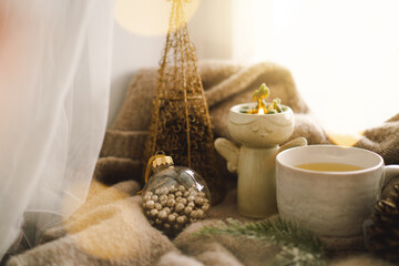 Christmas composition. Hot tea, candles, Christmas golden balls and decorations. Christmas holiday mood. Winter concept.