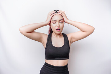 Fototapeta premium A portrait of an sporty Asian woman wearing a sportswear isolated by white background looks depressed