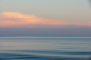 Naklejka na ściany i meble Clouds over Atlantic Ocean Long Exposure at Sunset Abstract