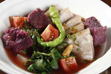 Pork sinigang with ube, a soup from the Philippines made from pork, varous vegetables and tamarind-based soup